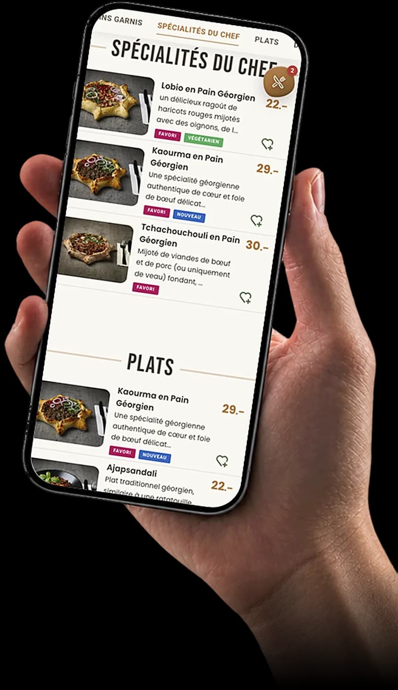 Main tenant un téléphone affichant un vrai menu QR avec photos